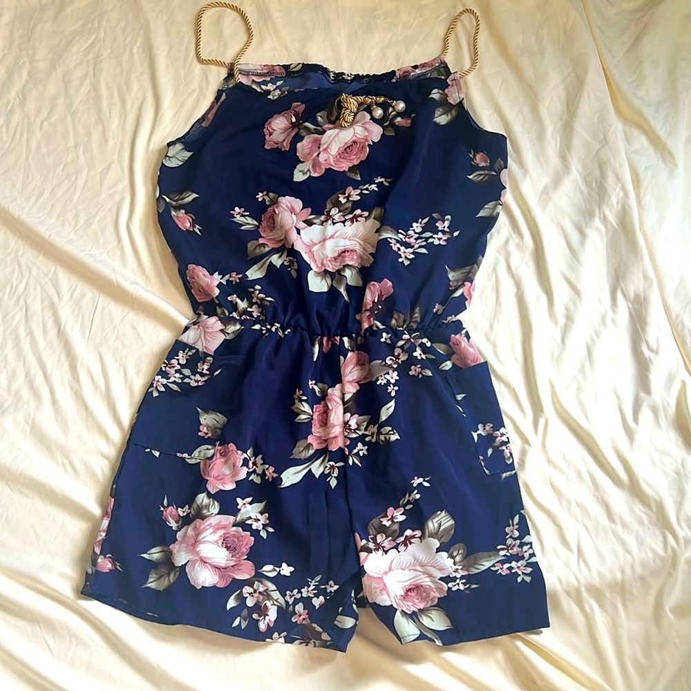 This romper comes with two side pockets. The floral details are beautiful.